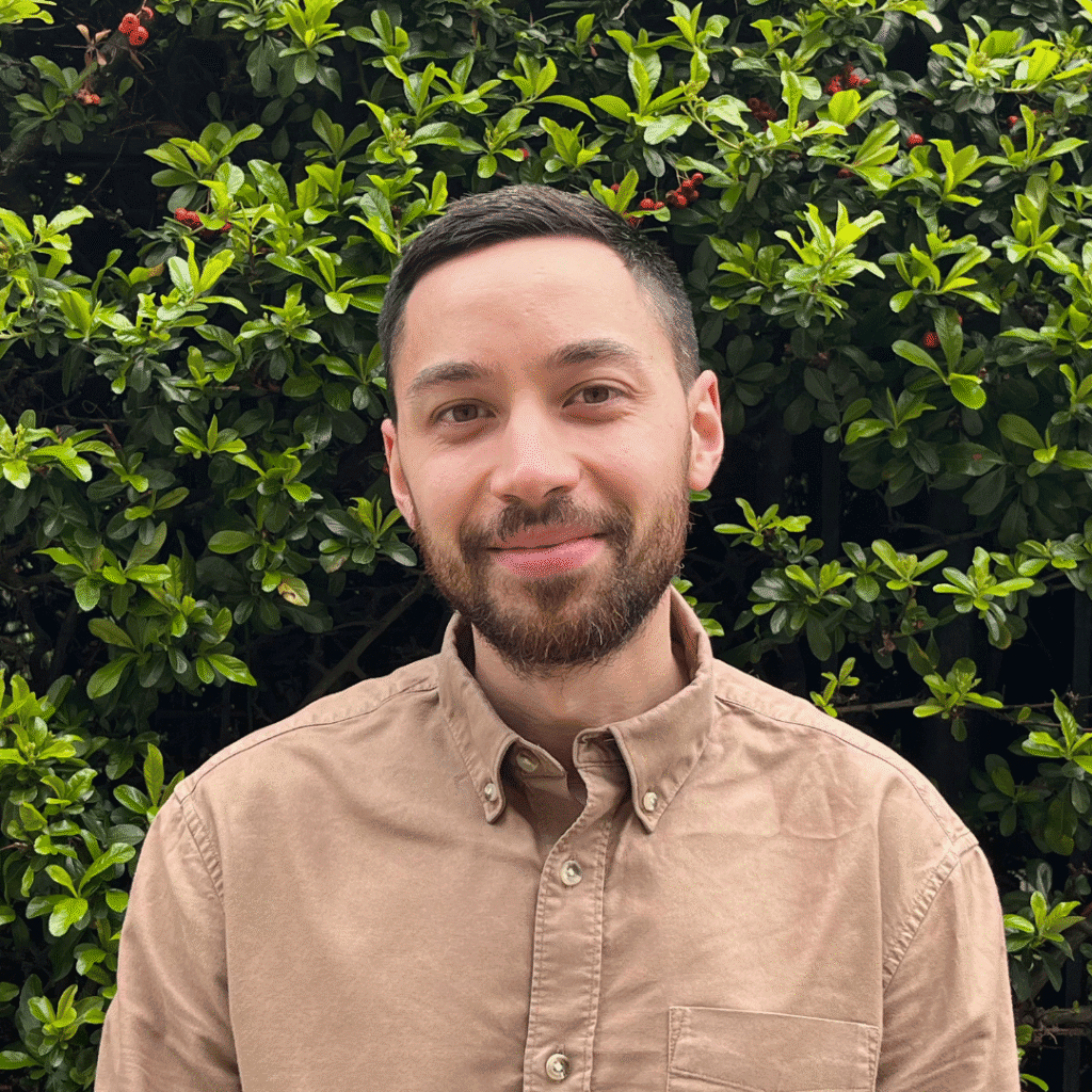 image of Shaun Leo with a brown shirt and a hedge in a background