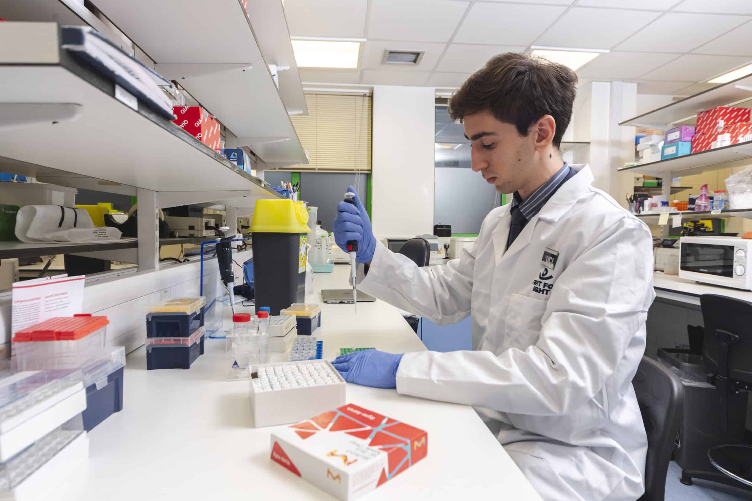 individual in white lab coat performs an experiment