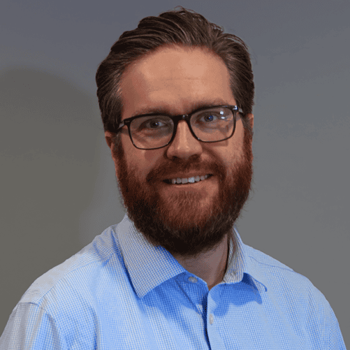 Image shows a white male with reddish hear and beard wearing a blue shurt