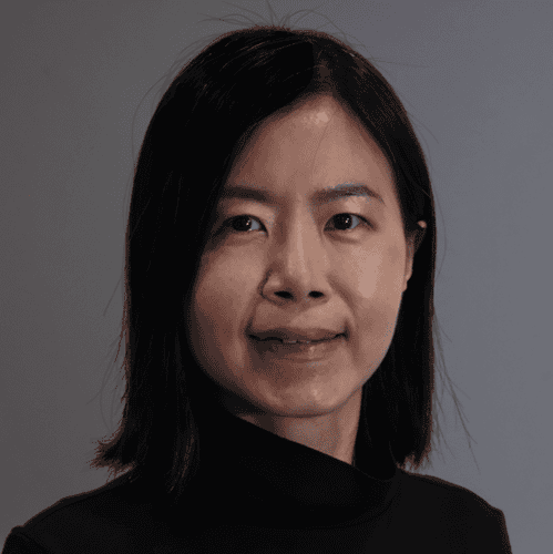 Image shows a female with dark bobbed har wearing a black top