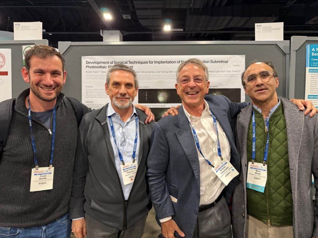 Image shows four men in front of a poster for the PRIMA trial at ARVO 2026 from left to right. Prof Frank Brodie, Assistant Professor of Ophthalmology and Vitreoretinal Surgery at University of California San Francisco (PRIMA Investigator and Medical Director at Science Corporation , USA). Prof Daniel Palanker, Stanford University (inventor of PRIMA). Prof Andrea Cusumano, University of Rome Tor Vergata (PRIMA investigator) Dr. Mahi Muqit PI on the PRIMA trail 