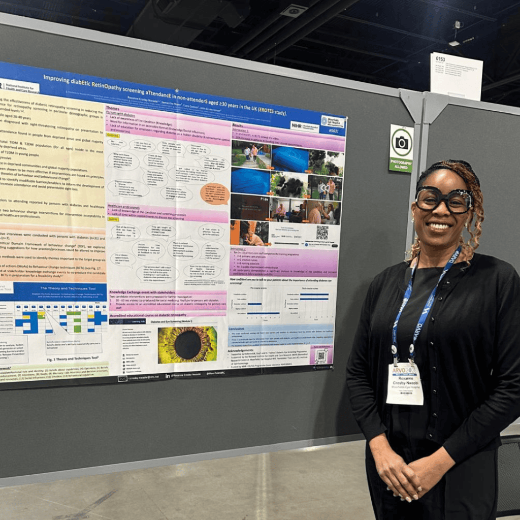 A conference poster presentation displayed on a grey board, titled about improving diabetic retinopathy screening attendance in non-attenders aged 30 and over in the UK (EROTES study). The poster includes sections with text, diagrams, charts, and photographic images. To the right, a person wearing glasses, a black outfit, and a conference lanyard stands beside the poster.