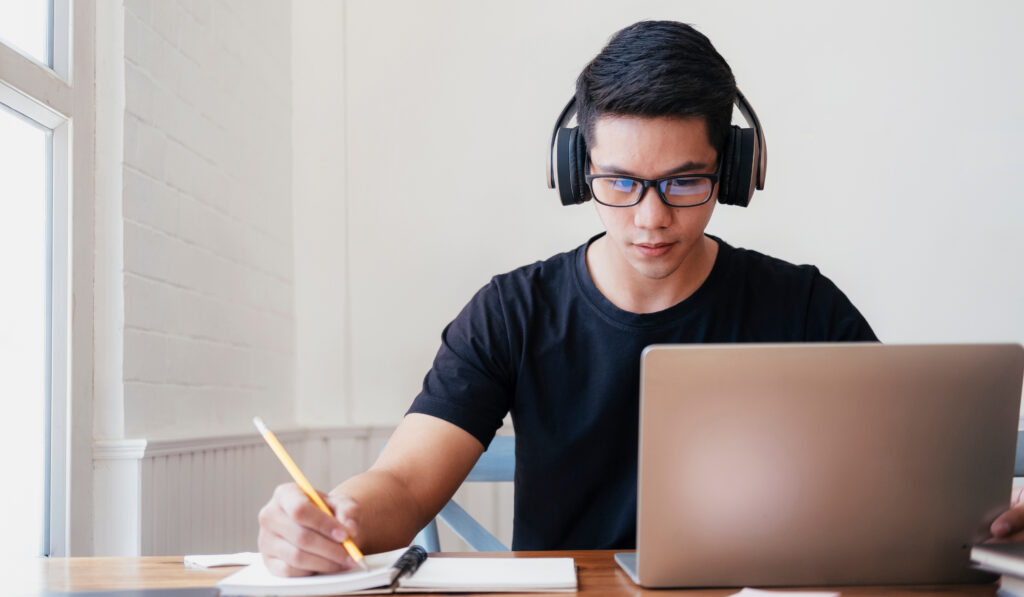 Young man student study at home. He using laptop and learning online.