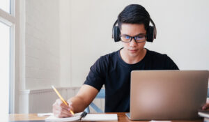 Young man student study at home. He using laptop and learning online.