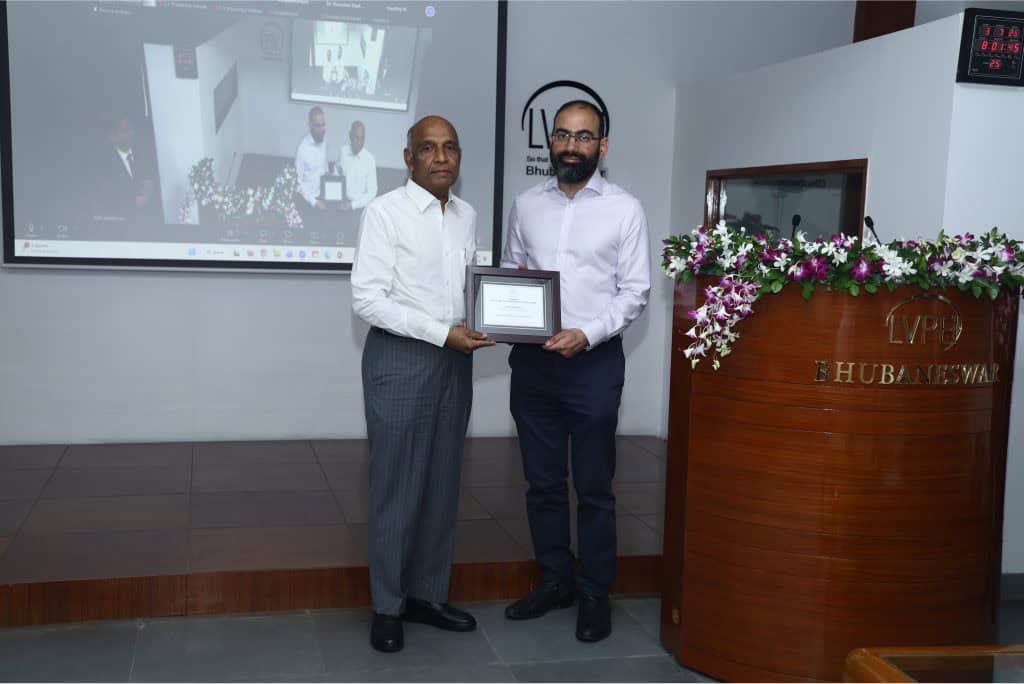 Image shows two men holding a plaque