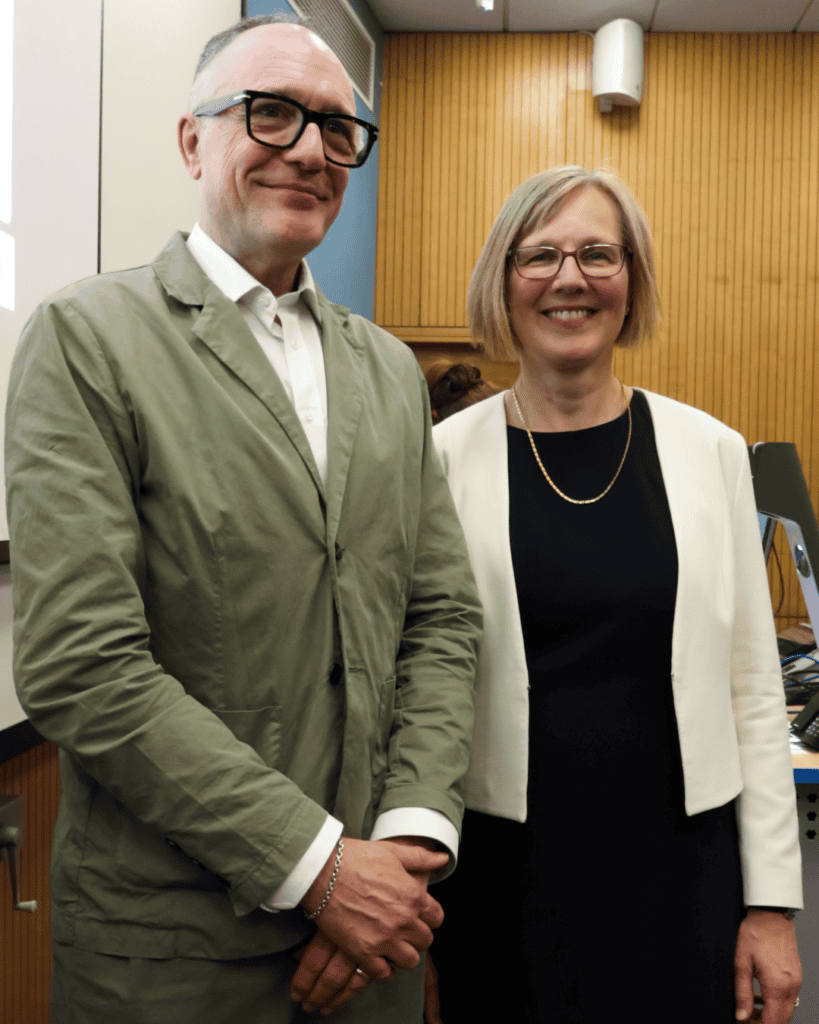 Two academics posing together at the conclusion of an inaugural lecture in a university lecture theatre.